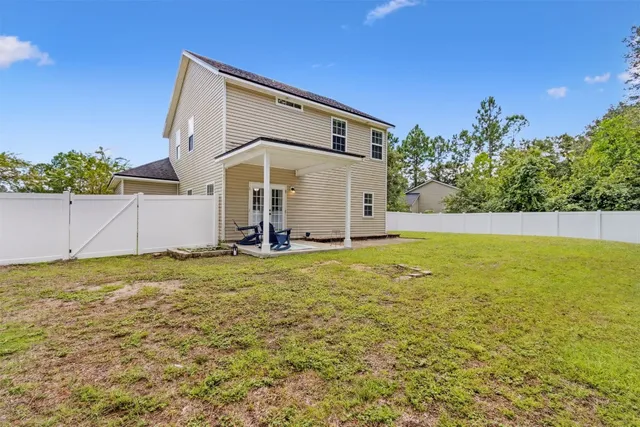 a view of a backyard with plants and large tree