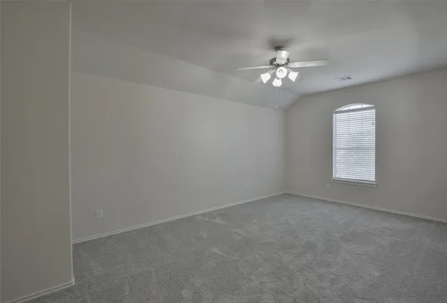 an empty room with a window and a ceiling fan