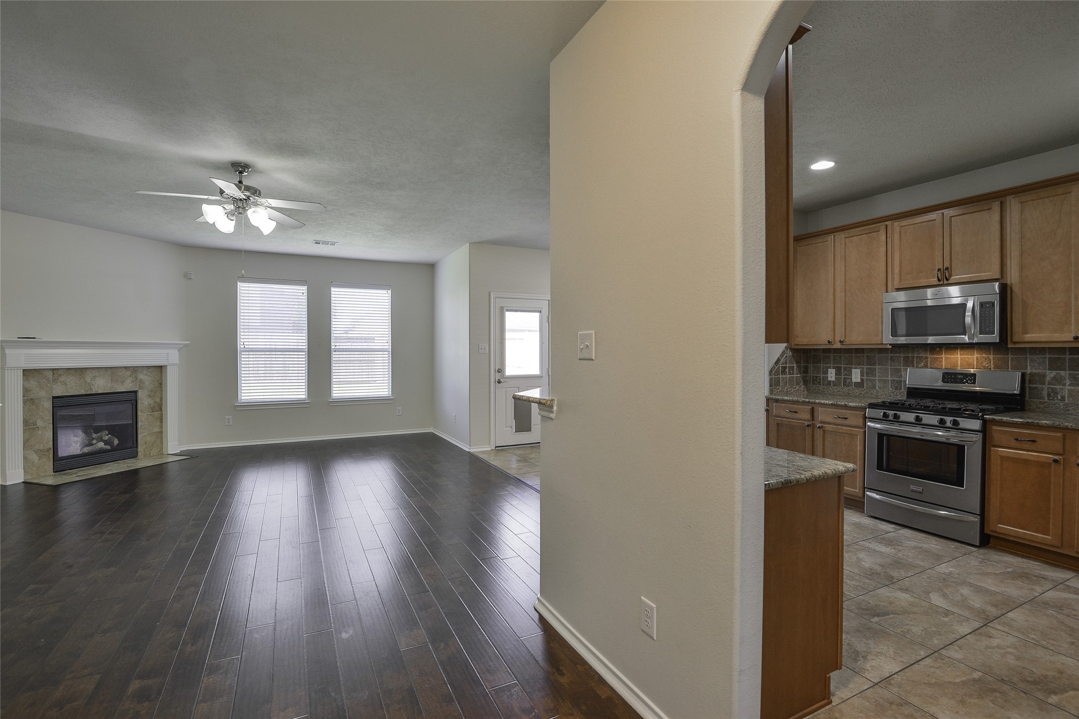 3618 Orchard Valley Lane Spring, TX 77386 - Photo 8 of 39 a view of a kitchen with a stove wooden cabinet a refrigerator a ceiling fan and wooden floor