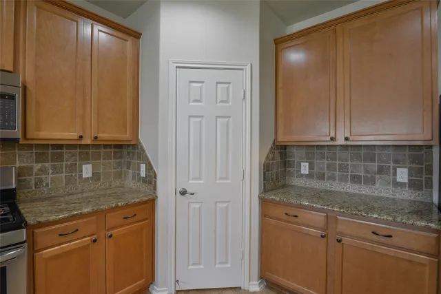 a kitchen with granite countertop white cabinets and white appliances