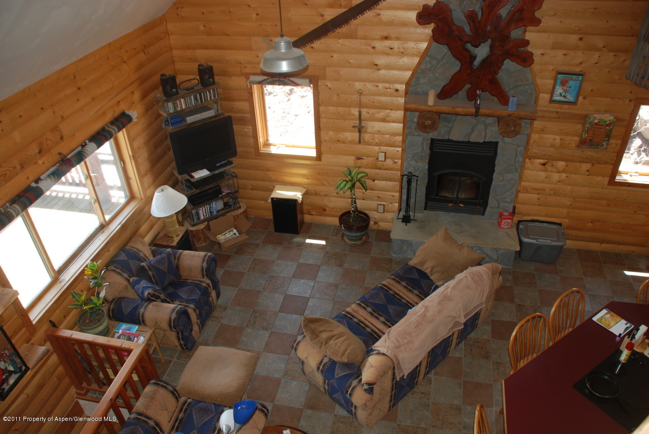 630 Foster Ridge Road Glenwood Springs, CO 81601 - Photo 13 of 27 a living room with furniture a fireplace and a flat screen tv