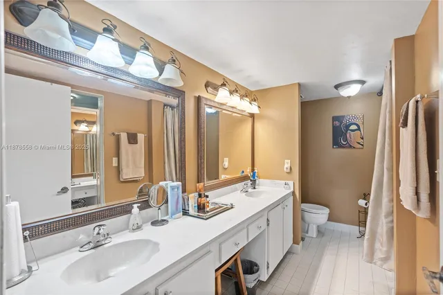 a spacious bathroom with a double vanity sink a mirror and a shower