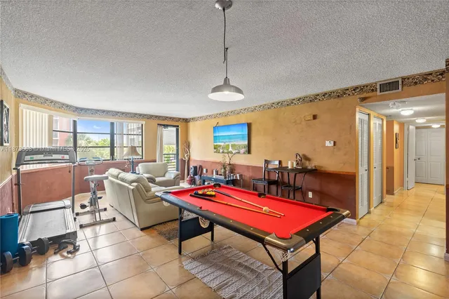 a room with pool table and windows