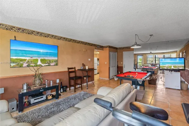 a living room with furniture kitchen view and a wooden floor