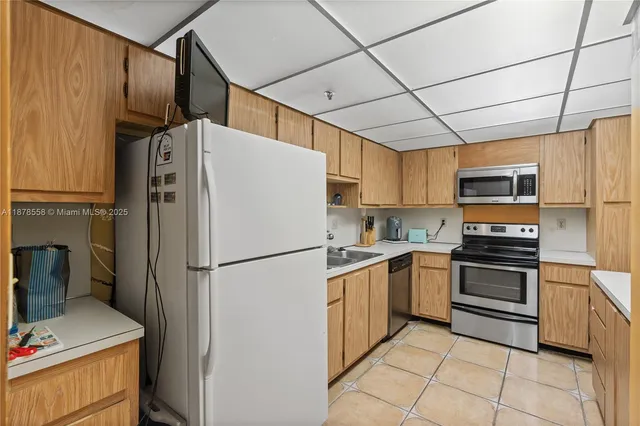 a white refrigerator freezer and a stove sitting inside of a kitchen
