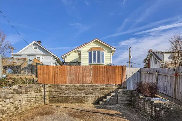a view of a house with wooden fence