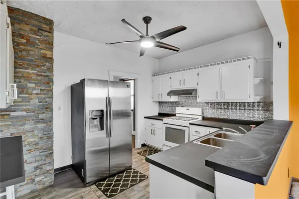 a kitchen with stainless steel appliances granite countertop a sink stove and refrigerator