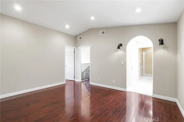 a view of empty room with wooden floor and window