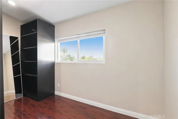 an empty room with wooden floor and closet