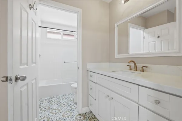 a bathroom with a granite countertop sink a mirror and a shower