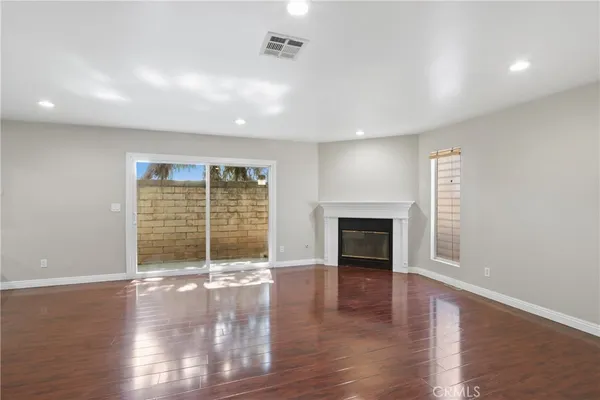 an empty room with wooden floor and fireplace