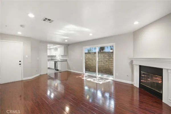 a view of empty room with wooden floor and fireplace
