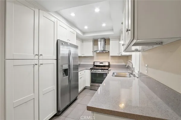 a kitchen with stainless steel appliances a refrigerator and a stove top oven