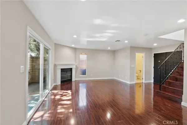 a view of empty room with wooden floor and fireplace