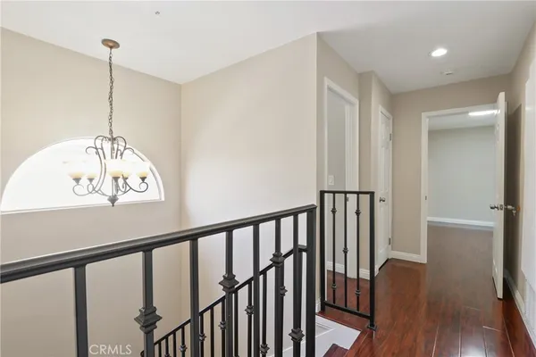 a view of a hallway to room with wooden floor