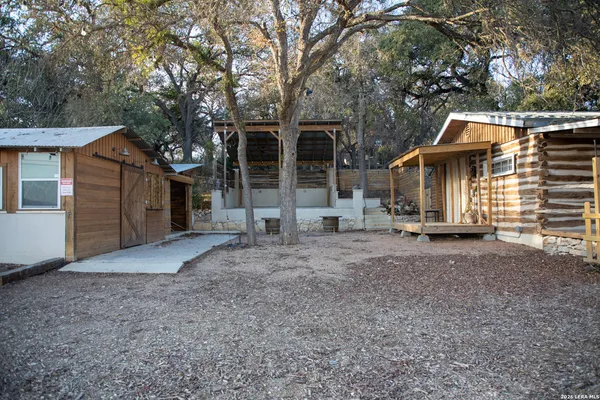 a view of a house with a yard and large tree