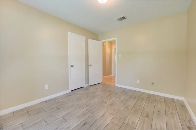 a view of an empty room with wooden floor