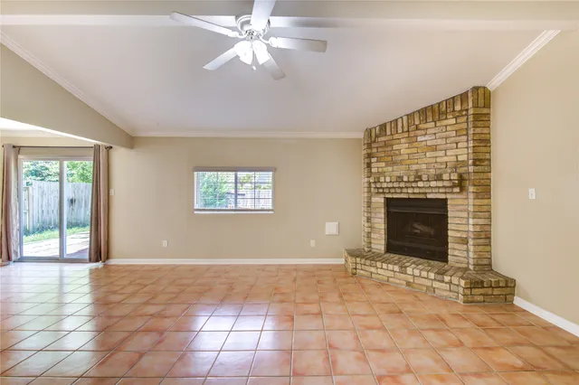 a view of an empty room with window and chandelier fan