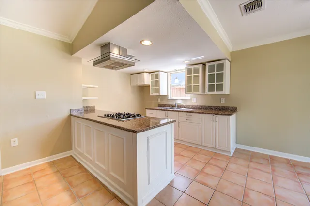 a kitchen with granite countertop a sink and a stove
