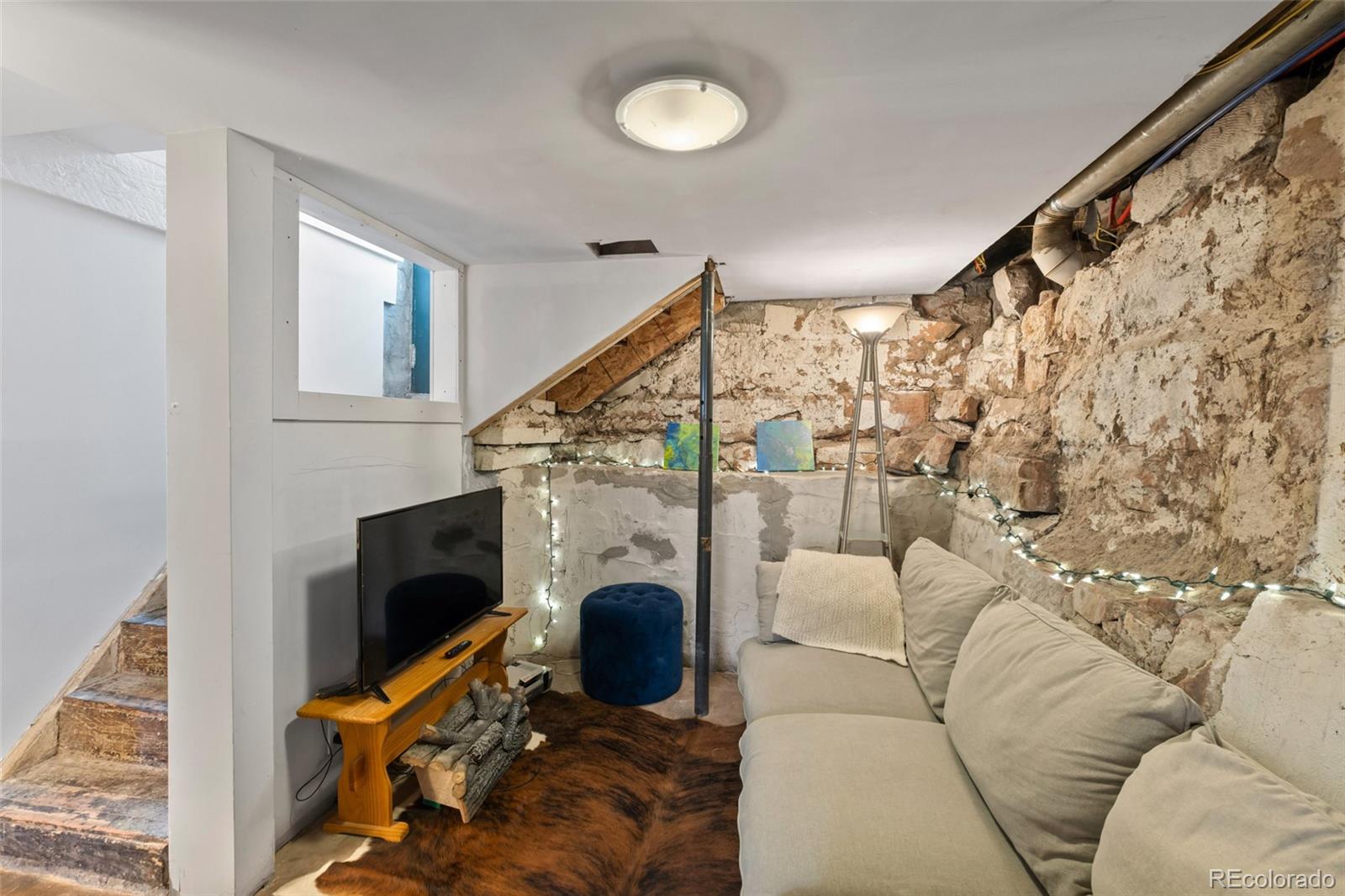 1047 Meade Street Denver, CO 80204 - Photo 27 of 38 a living room with furniture a fireplace and a flat screen tv