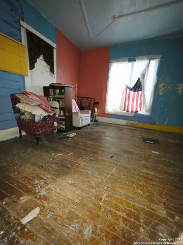 a living room with a bed furniture and a window