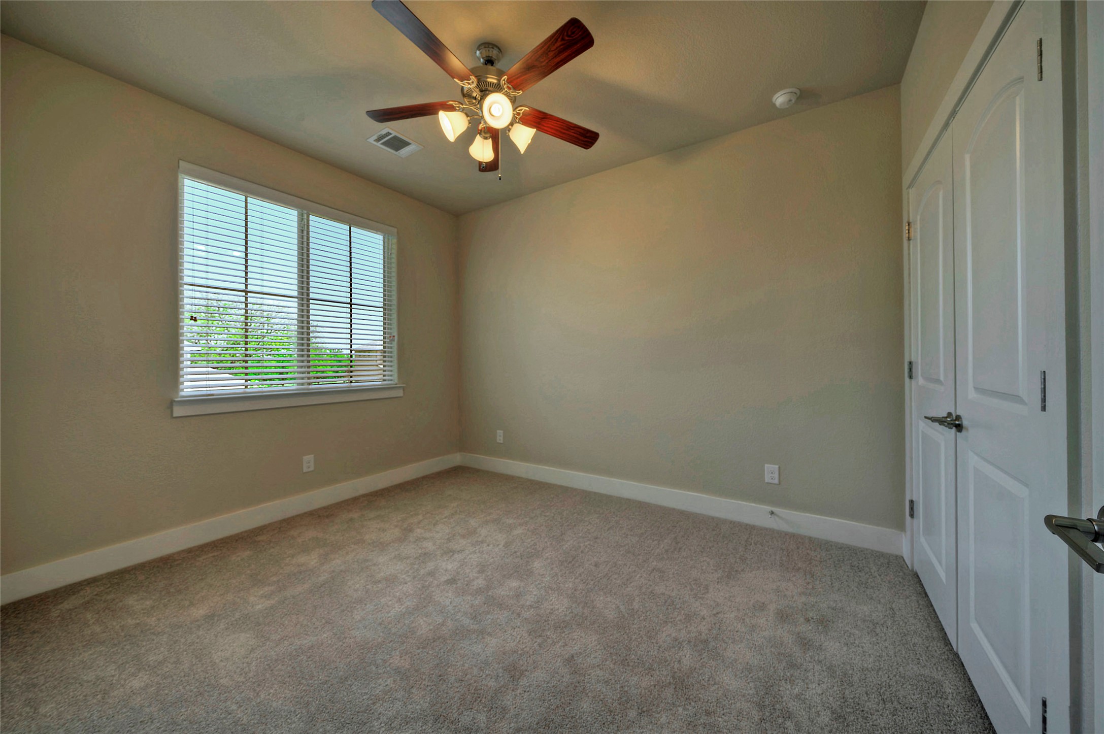 508 High Tech Drive, Unit B Georgetown, TX 78626 - Photo 21 of 24 A well-lit bedroom features plush carpeting and a modern ceiling fan, ready for personal touches.