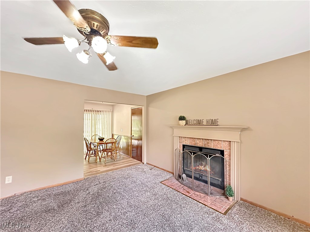 596 Hadcock Road Brunswick, OH 44212 - Photo 7 of 17 Living area featuring light colored carpet, a tile fireplace, and ceiling fan