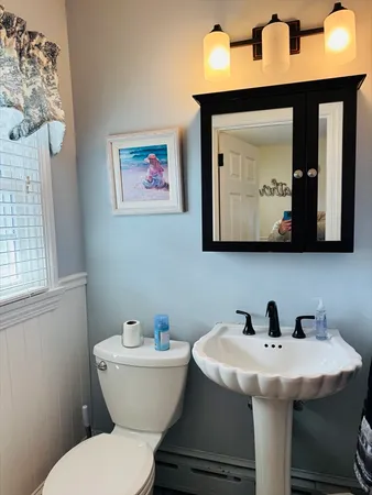 a bathroom with a toilet a sink and mirror