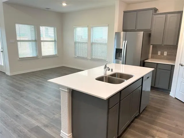 a kitchen that has a sink a refrigerator and window