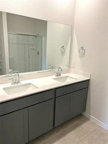 a bathroom with a double vanity sink and a mirror