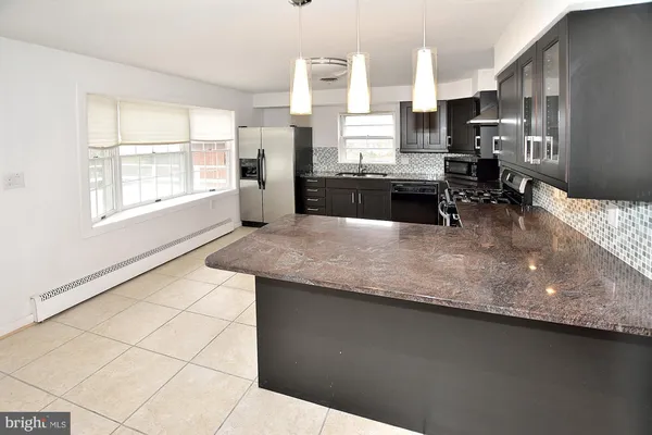 a kitchen with stainless steel appliances kitchen island granite countertop a sink counter space and a window