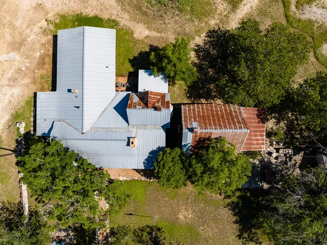 an aerial view of a house with a yard and sitting area