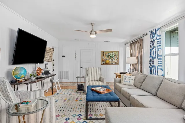 a living room with furniture a flat screen tv and a large window