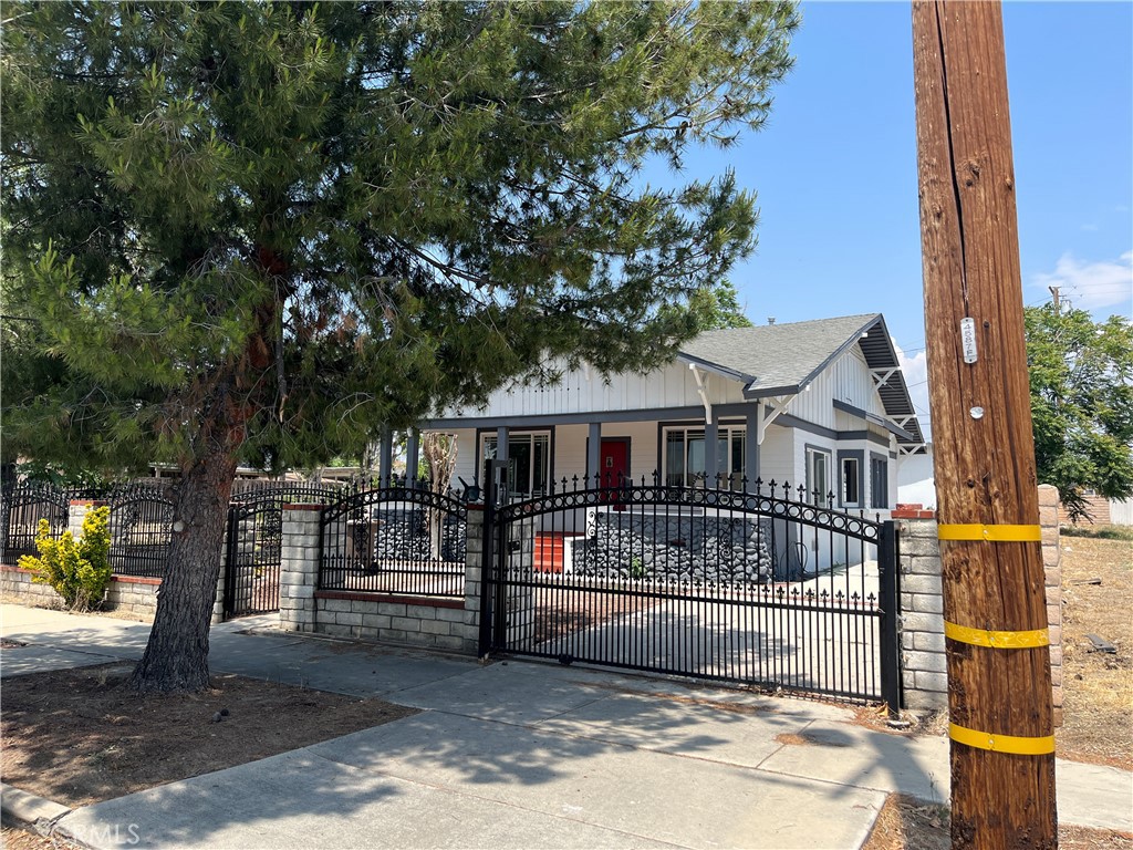 a view of a house with a wooden fence and a big yard
