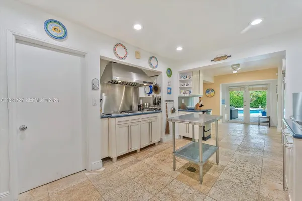 an aerial view of a tennis ground and a cars park side of the road