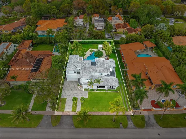 a bedroom with a bed a mirror on the dresser and flowerpot