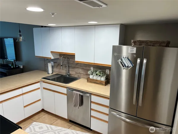 a kitchen with stainless steel appliances a refrigerator sink and stove