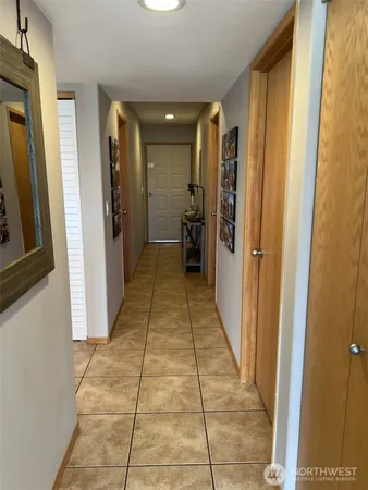 a view of a hallway with wooden floor and a bathroom