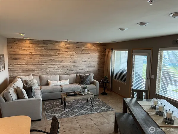 a living room with furniture floor to ceiling window and a flat screen tv