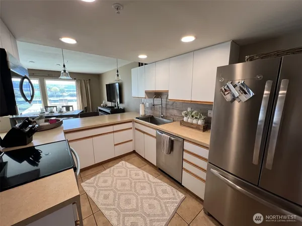 a kitchen with a refrigerator a sink and cabinets
