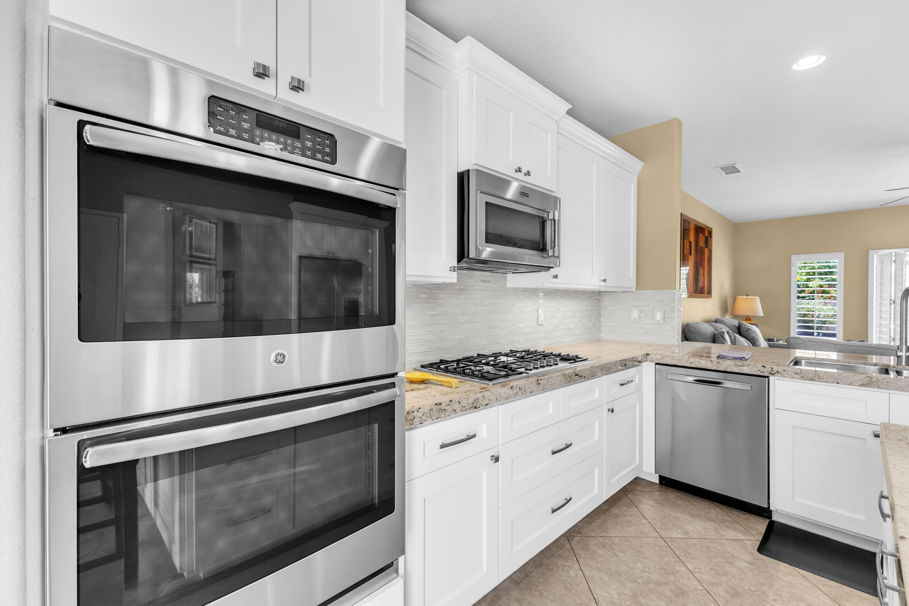 47845 Vía Opera La Quinta, CA 92253 - Photo 12 of 47 a kitchen with stainless steel appliances granite countertop white cabinets a stove a sink and dishwasher
