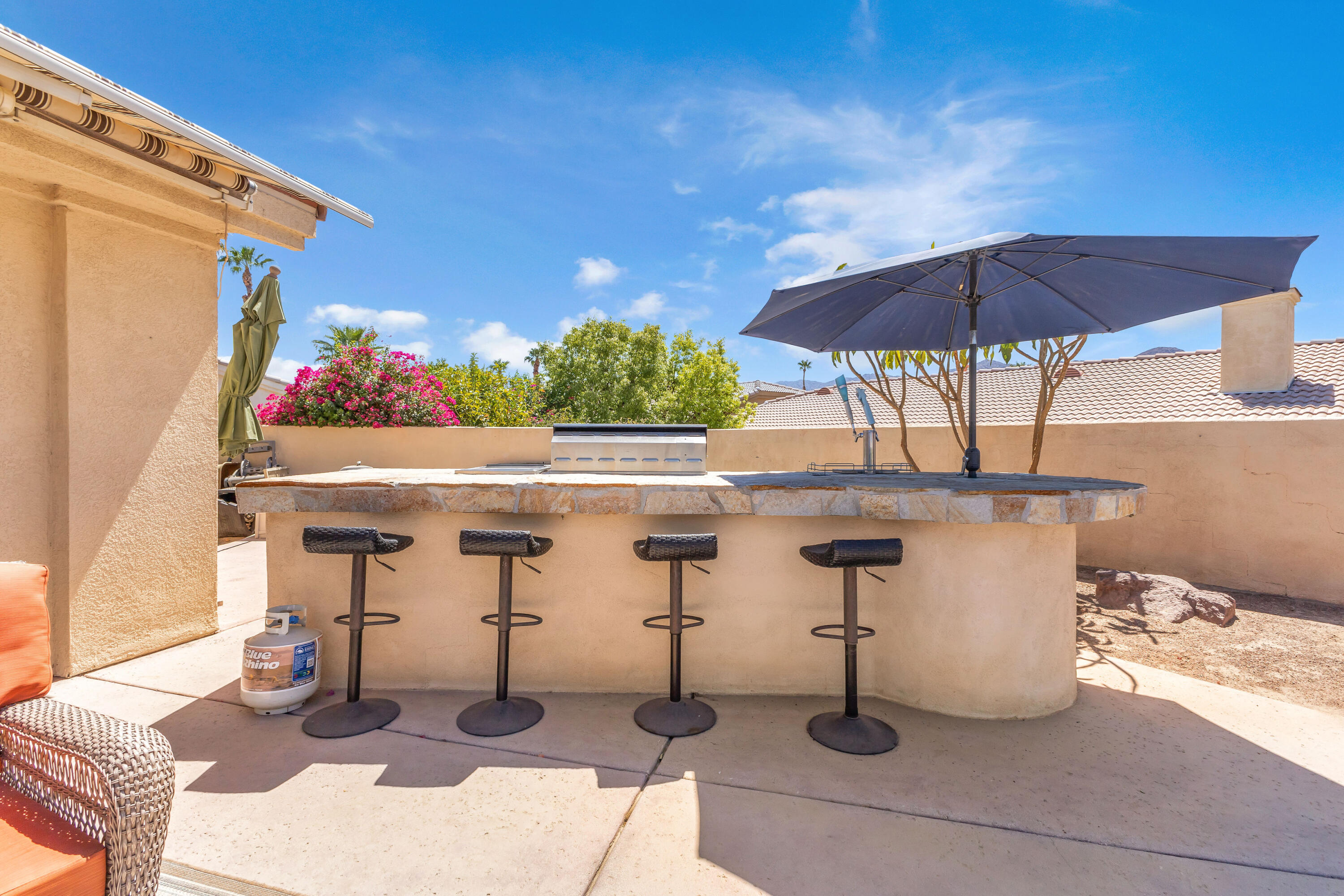 47845 Vía Opera La Quinta, CA 92253 - Photo 25 of 47 a view of a patio with table and chairs under an umbrella