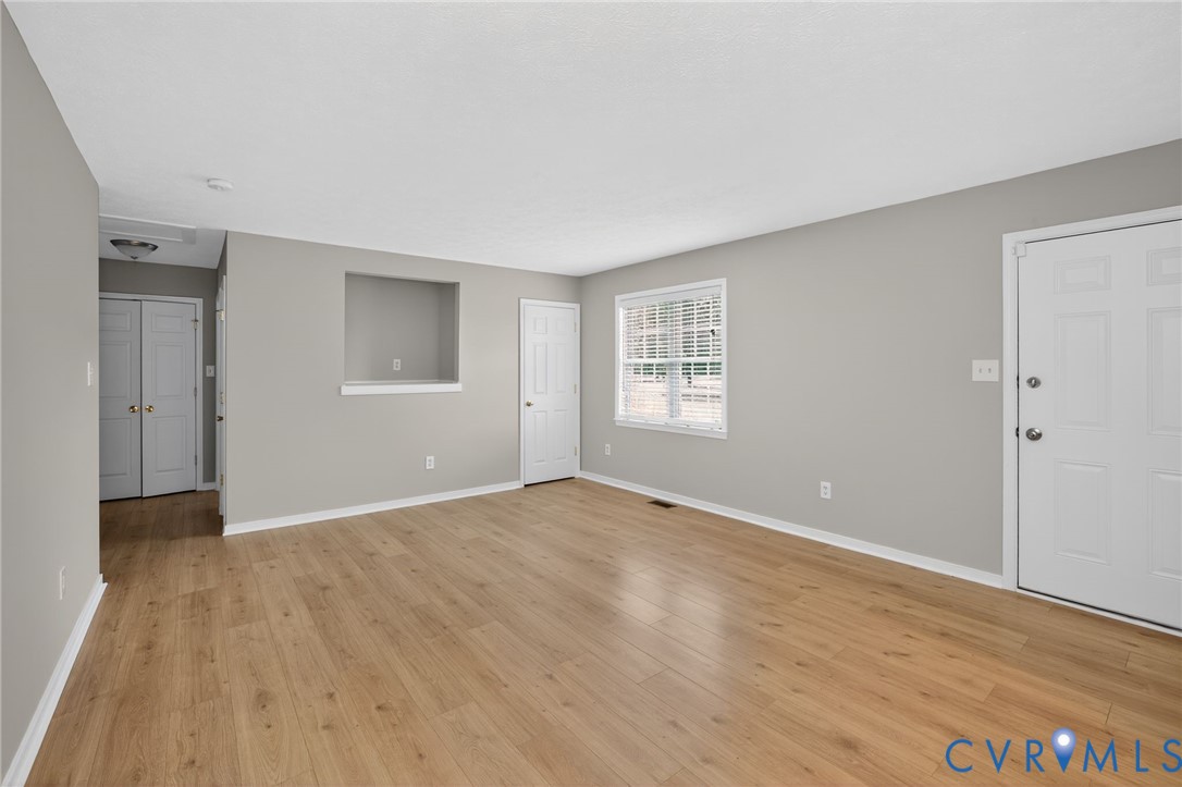 1827 Clarkson Road Richmond, VA 23224 - Photo 4 of 24 a view of an empty room with wooden floor and a window