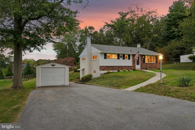 a view of a house with a small yard and a large tree