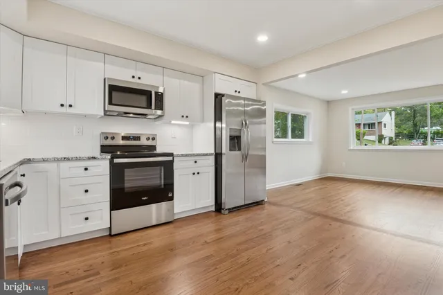 a kitchen with stainless steel appliances a stove microwave and refrigerator