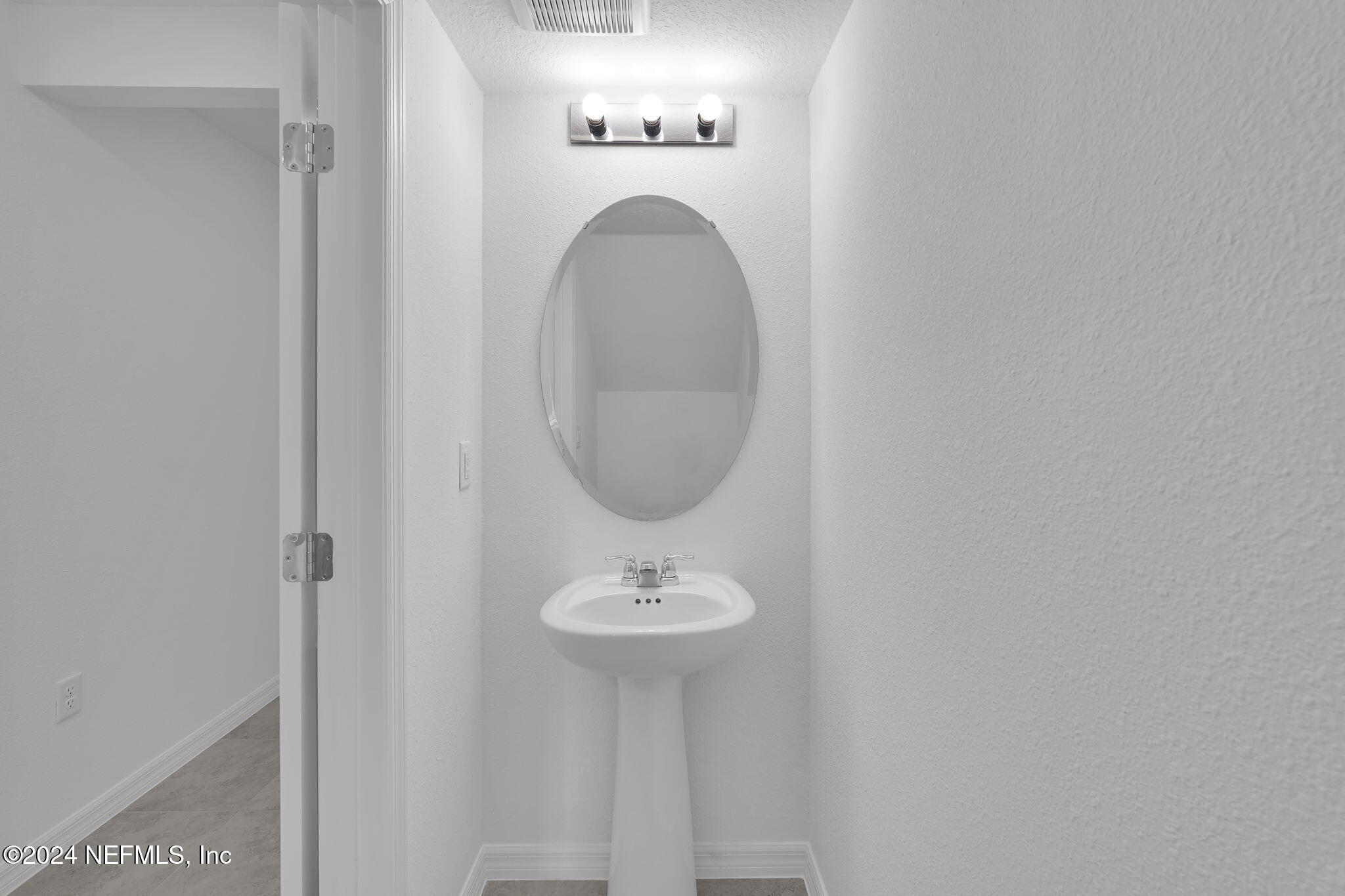 10121 Deep Pine Jacksonville, FL 32221 - Photo 13 of 24 a bathroom with a sink a mirror and a window