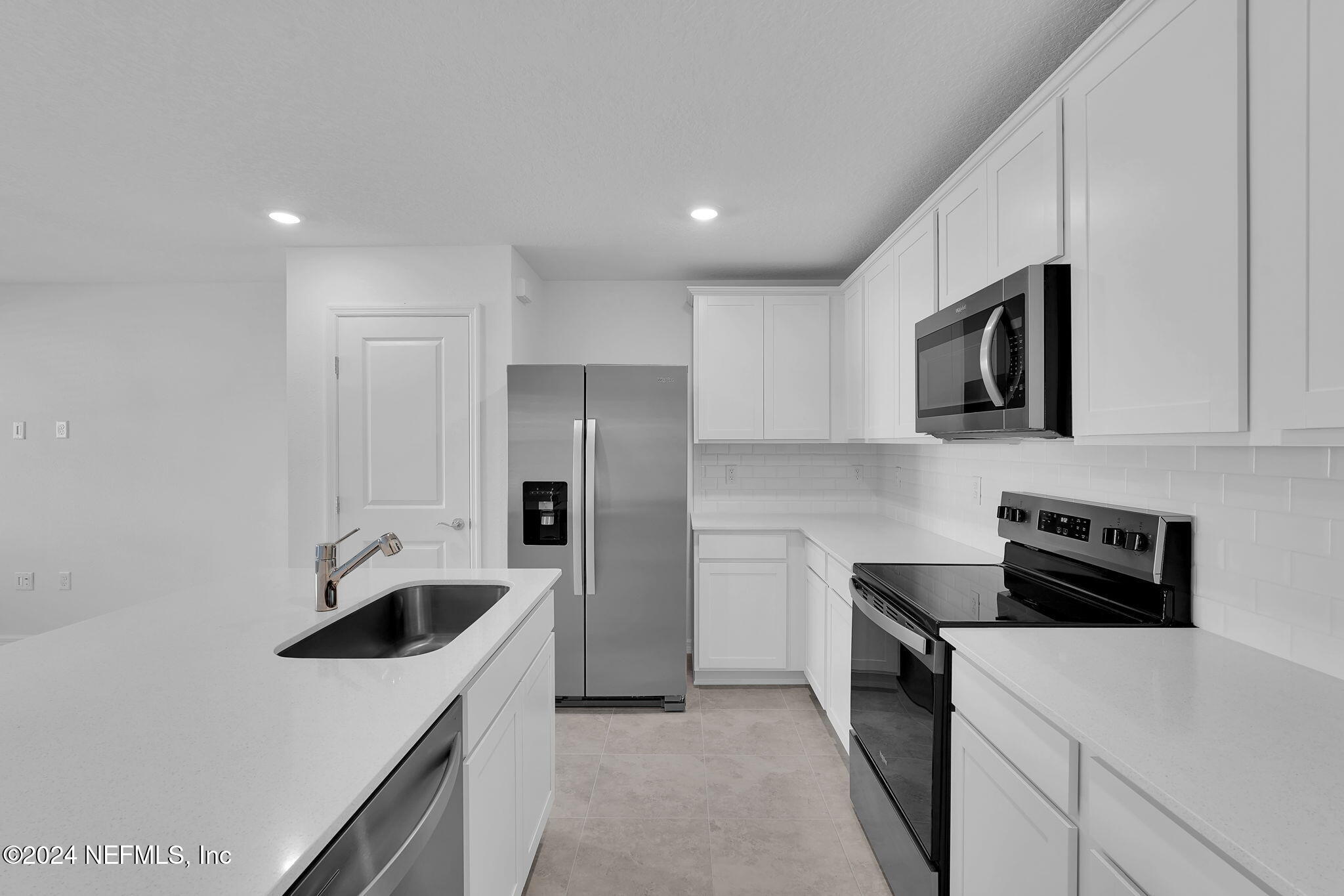 10121 Deep Pine Jacksonville, FL 32221 - Photo 7 of 24 a kitchen with stainless steel appliances a refrigerator sink and white cabinets