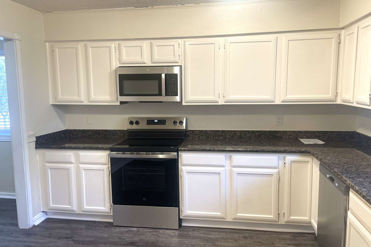 1819 Pilgrims Point Drive Friendswood, TX 77546 - Photo 5 of 10 a kitchen with granite countertop a stove and a microwave