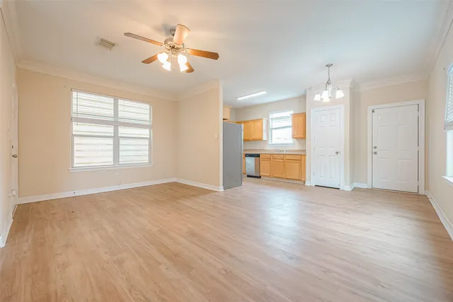 a view of an empty room with a window and wooden floor