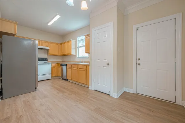 a view of a kitchen with a sink and a refrigerator